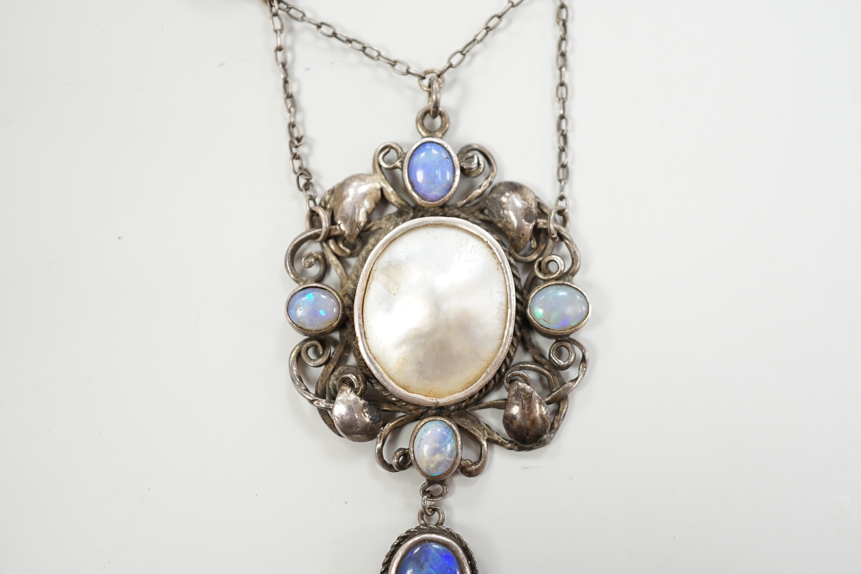 An Arts & Crafts white metal, mother of pearl and gem set drop pendant necklace, in the manner of Sybil Dunlop, overall 56cm.